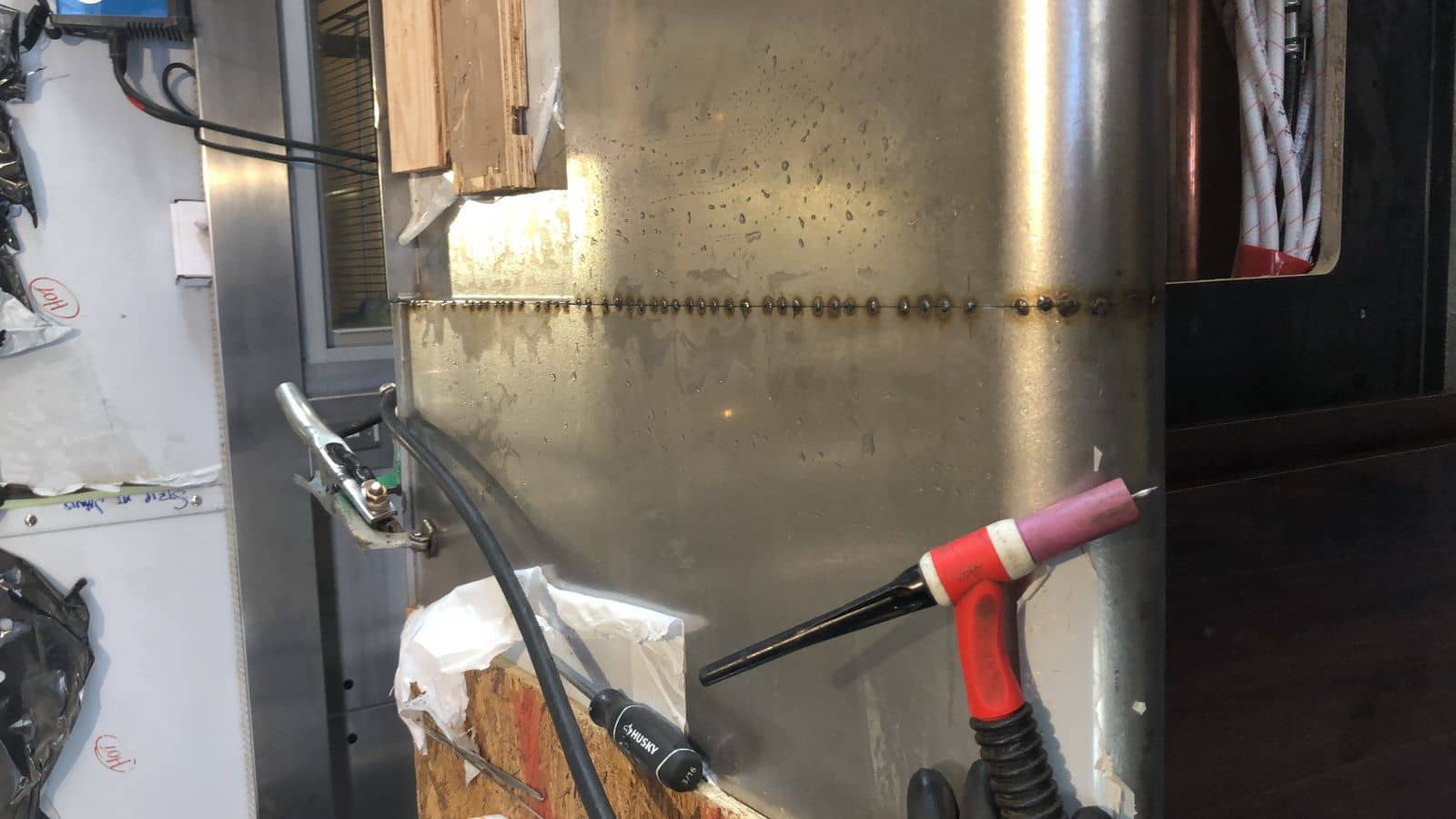 TIG torch and finished weld seam on stainless at Low's Custom Stainless