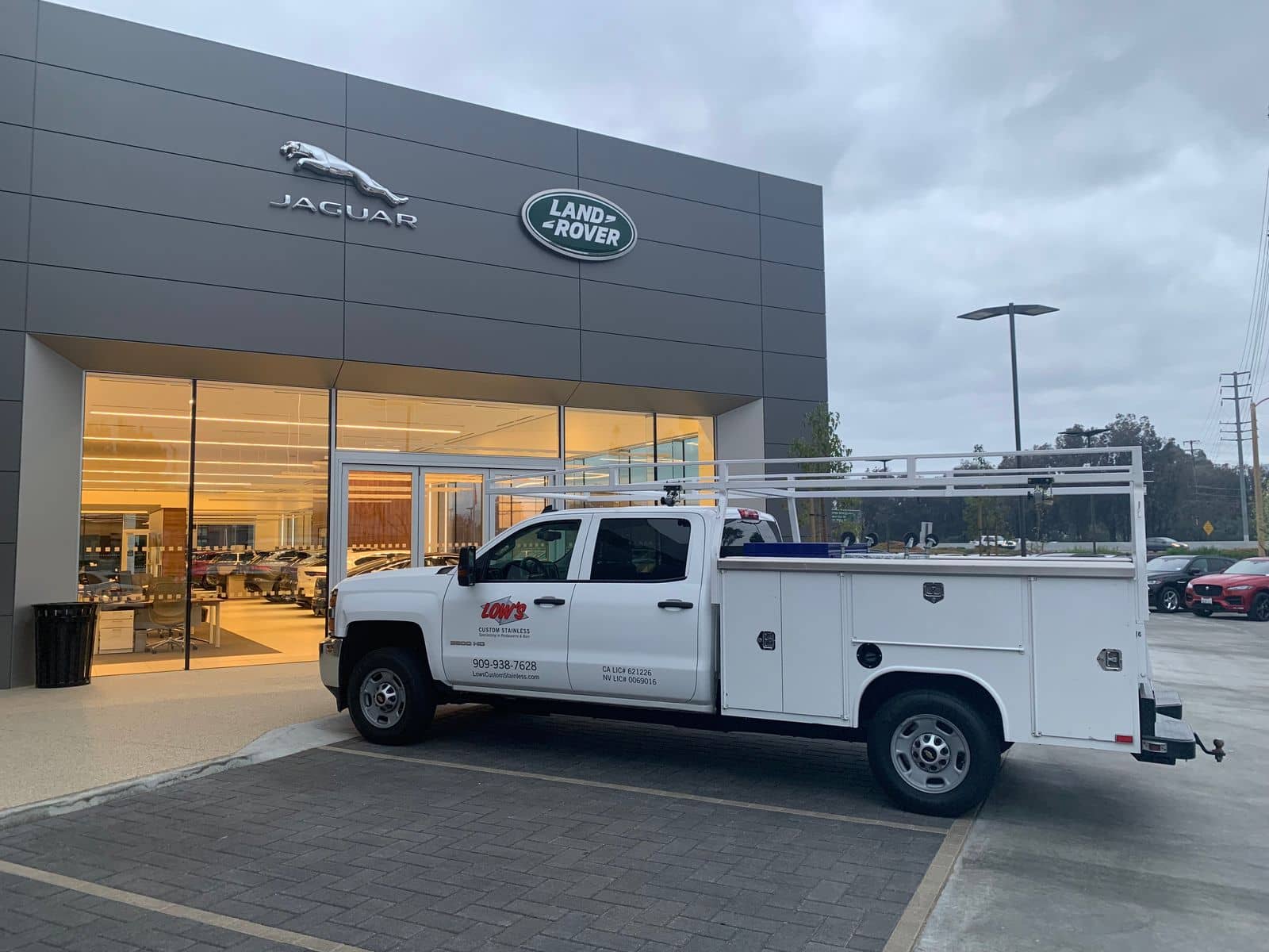 Low's Custom Stainless install truck on site at a luxury auto dealership