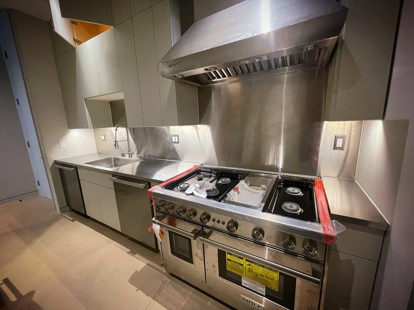 Stainless wall shelf, backsplash, and counter installed by Low's Custom Stainless